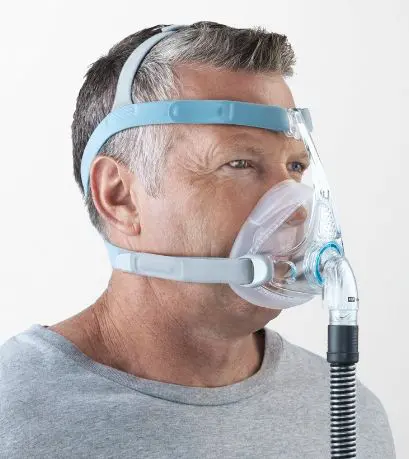 A man wearing an oxygen mask with a hose attached to it.